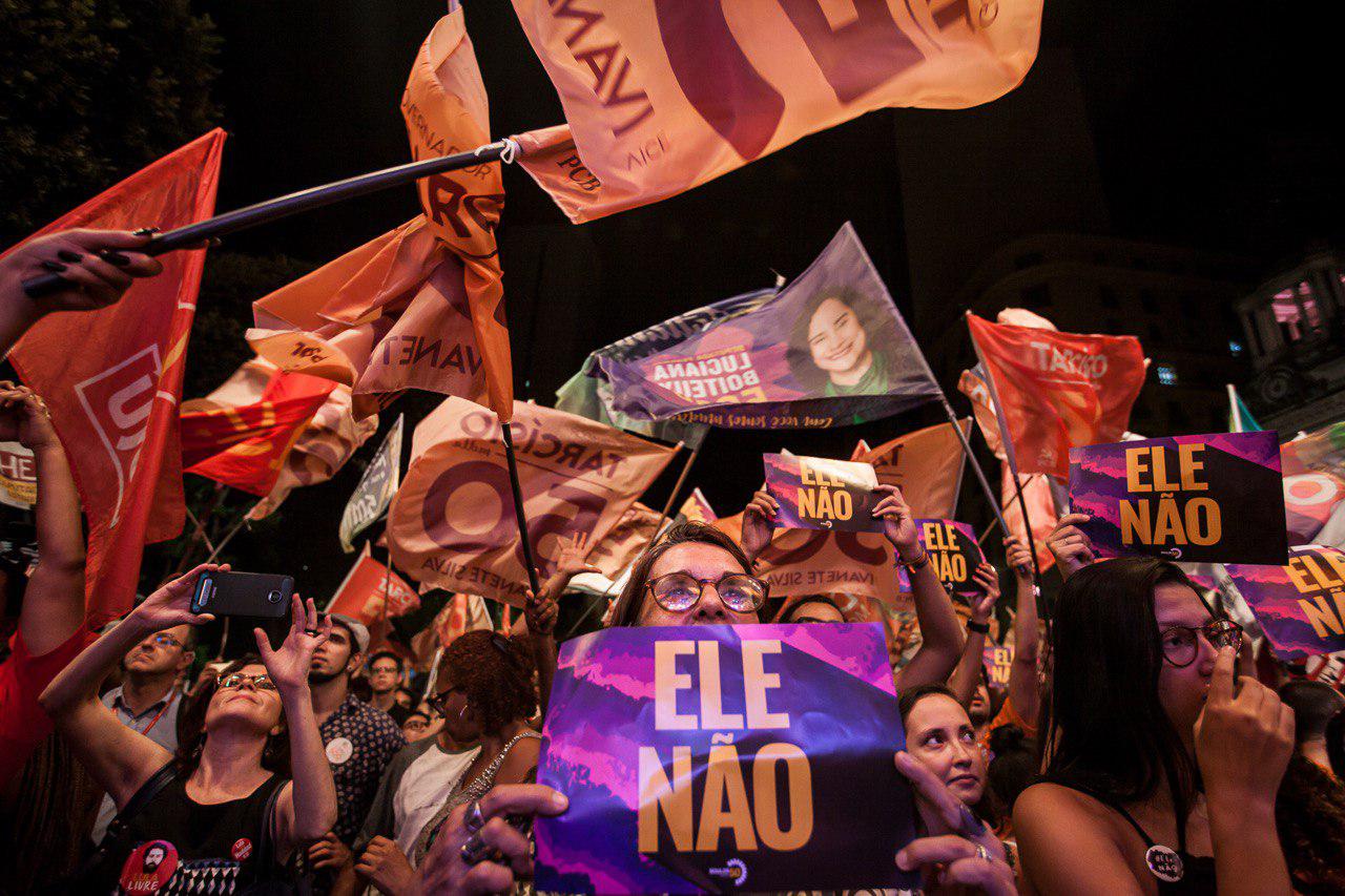 Una mujer sostiene un cartel contra Bolsonaro en un acto del candidato socialista Guilherme Boulos.
